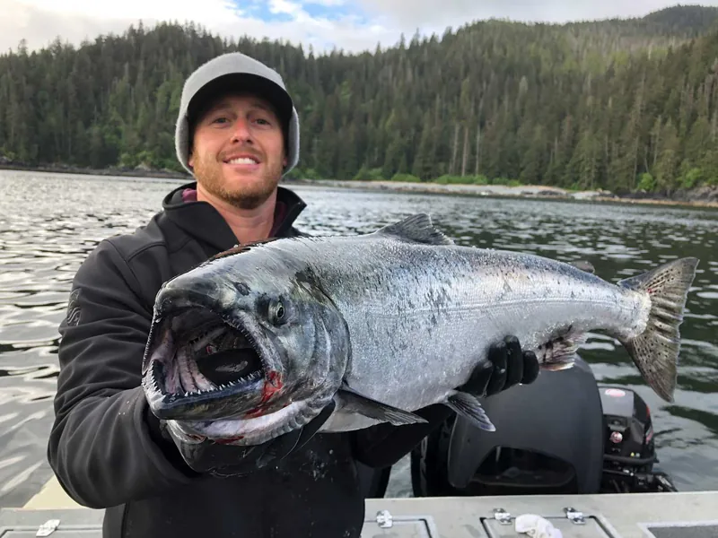 A guest holding a king salmon